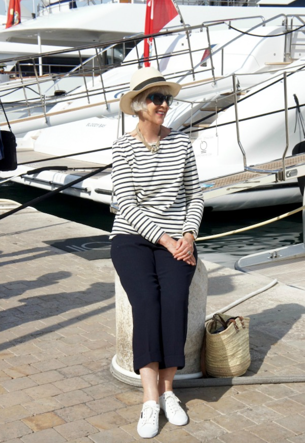 Breton sweater seated by large yacht