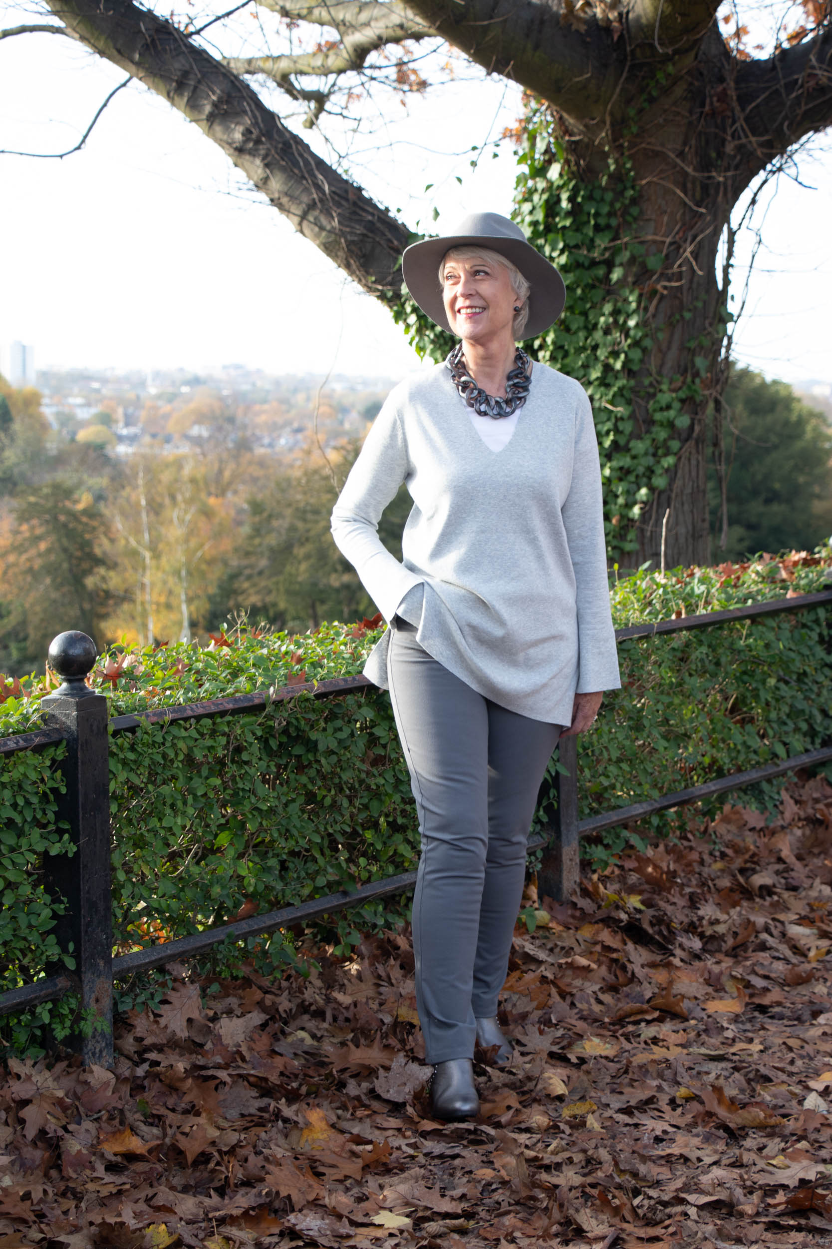 grey sweater, grey jeans, hat & necklace