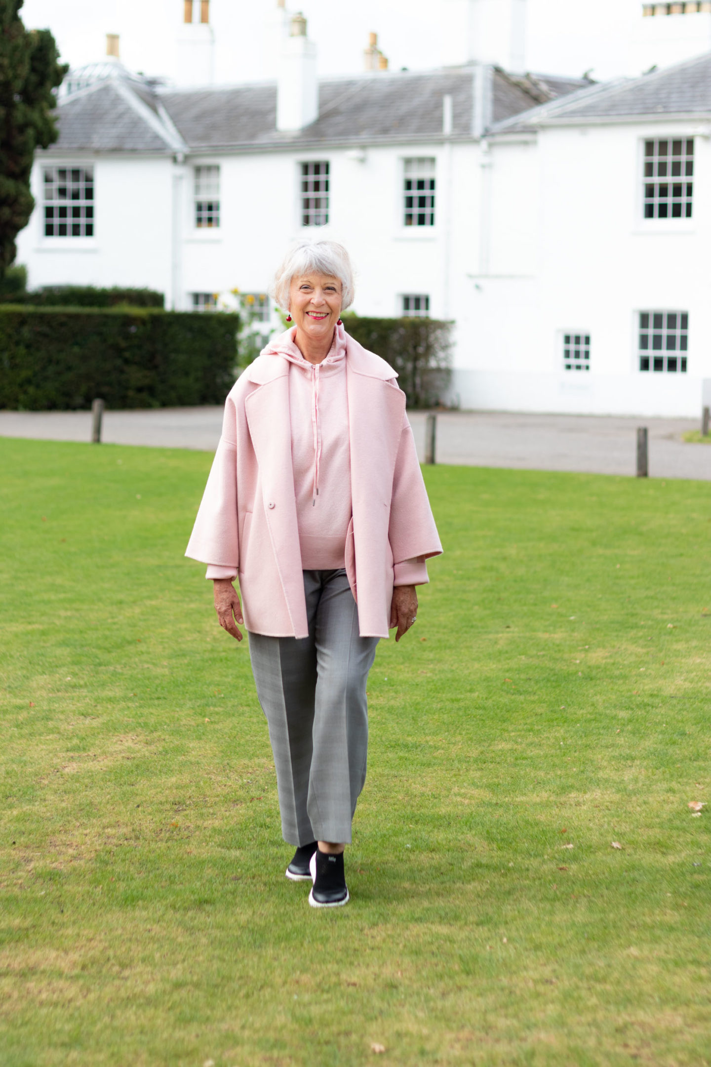 Pink coat, pink hoodie and grey trousers