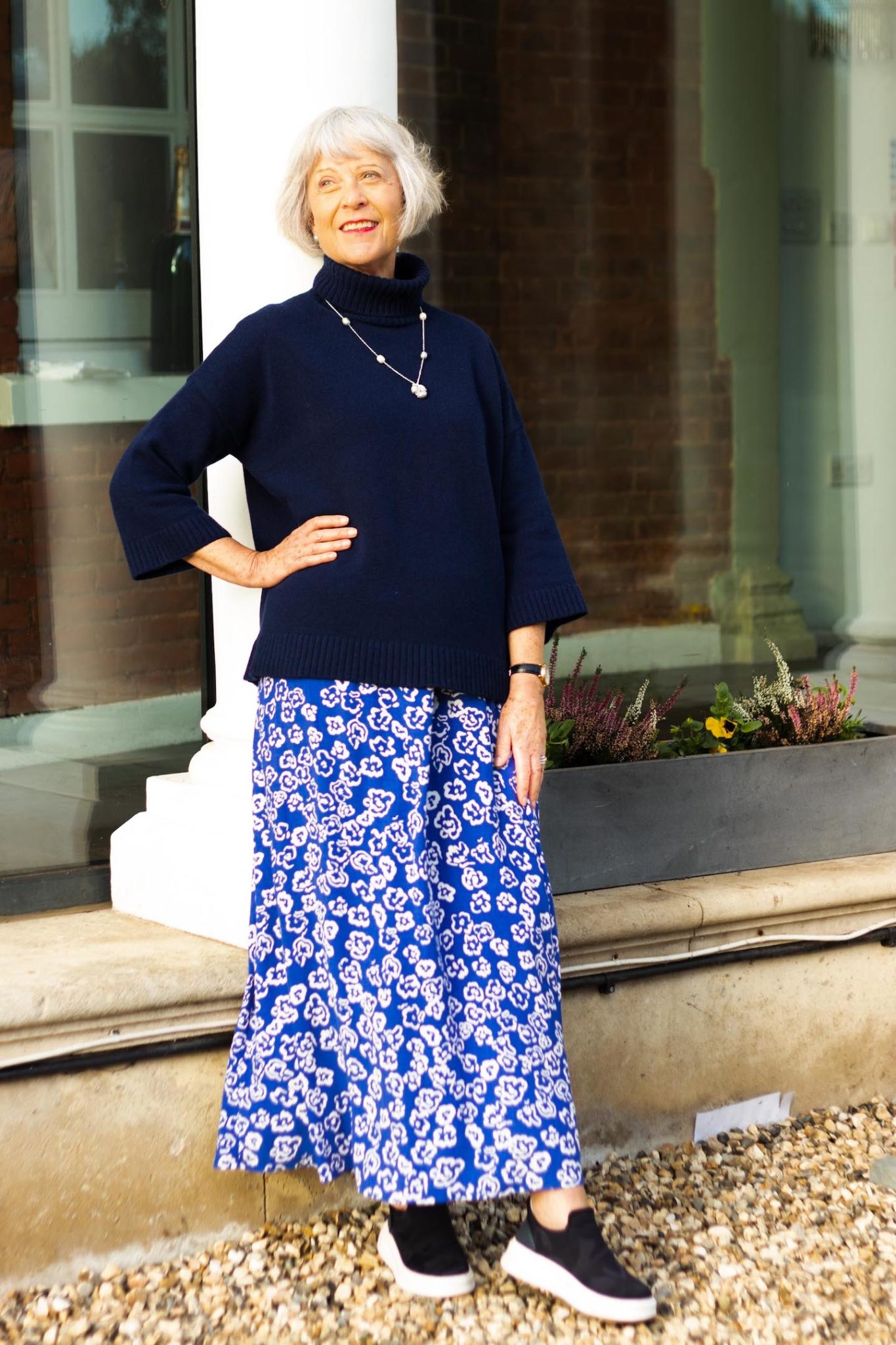 Print maxi skirt and navy polo sweater.