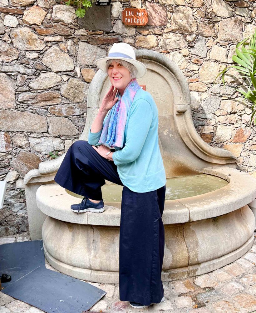 Wide leg navy trousers teamed with sweater, scarf and hat