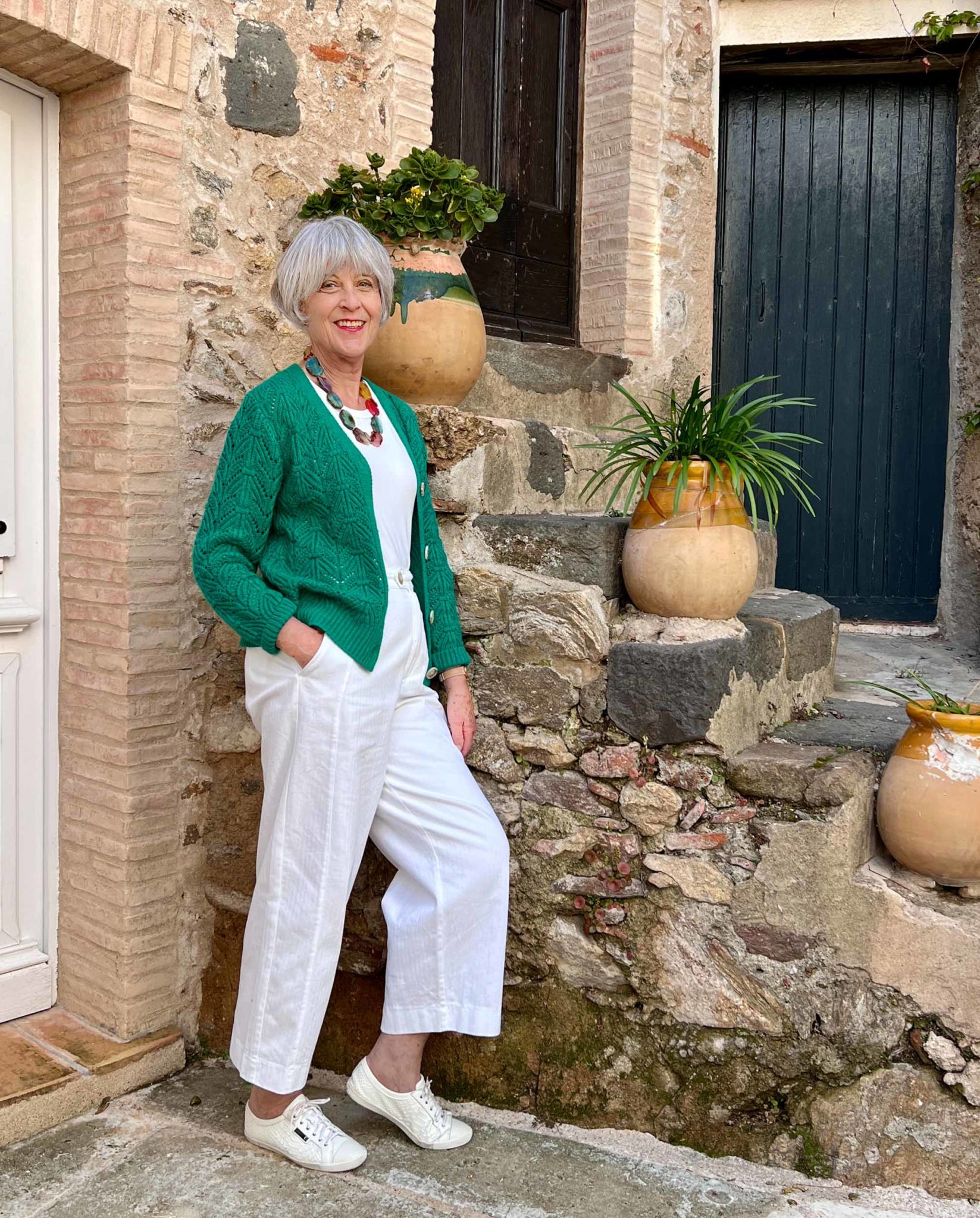 White trousers, white tee and green cardigan.