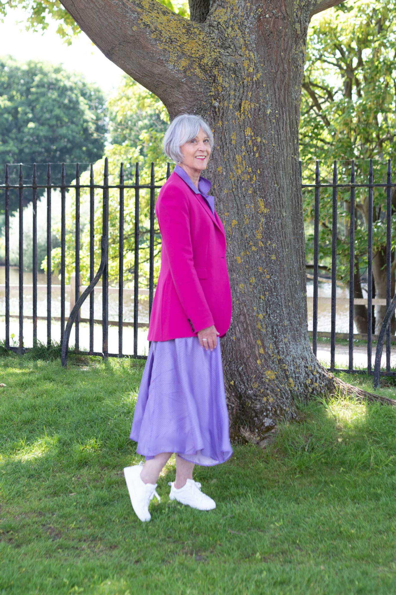 Purple maxi dress, pink jacket Pavers white trainers