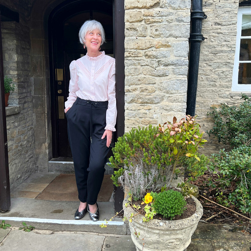 Pink cotton frill blouse and black trousers