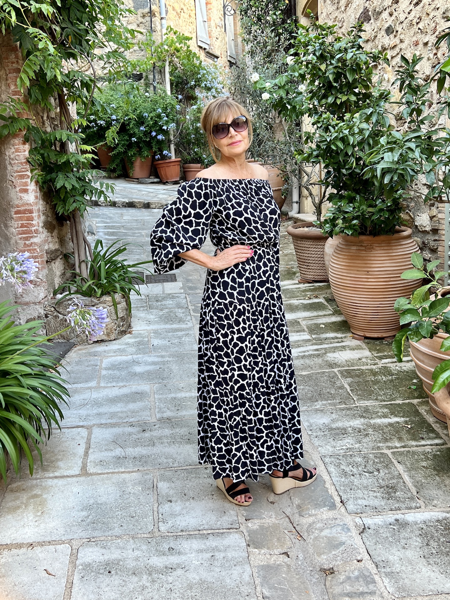 Black print dress worn off the shoulder